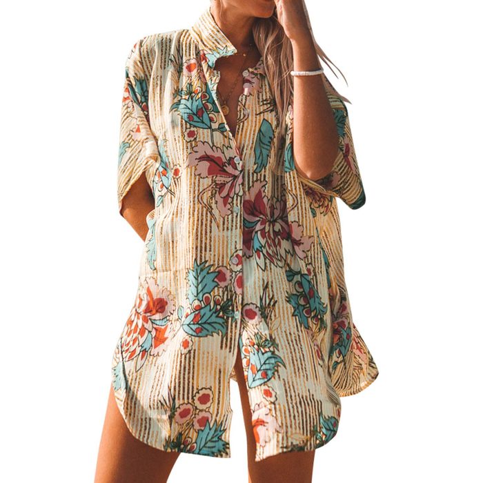Shirt with floral patterns hangs loosely on a standing person, set against a plain white background.