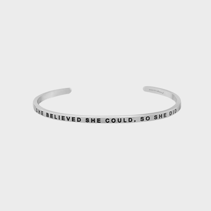 A silver bracelet displays the engraved text, 