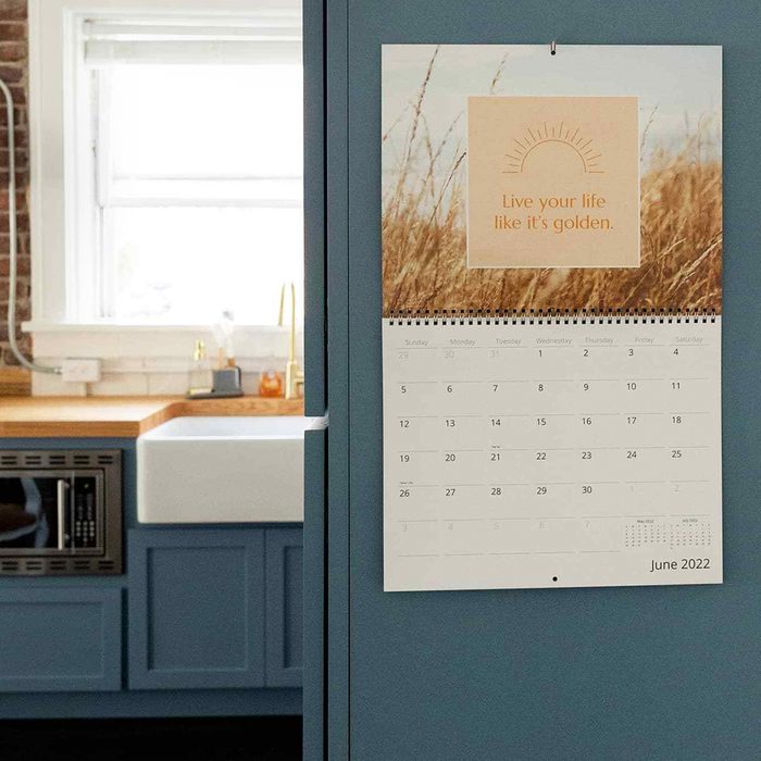 Calendar hangs on a blue cabinet with text, 