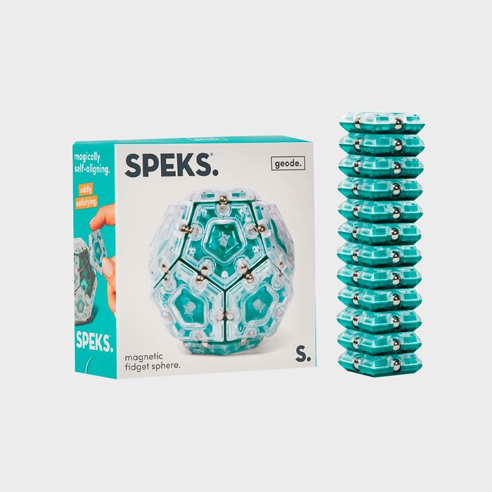 Box shows a magnetic fidget sphere; next to it, a stack of teal geometric pieces. Background is plain and white. Text includes 