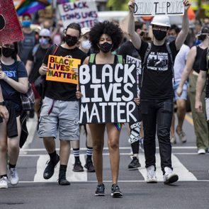 Protesters hold signs, including 