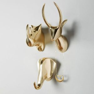 Metallic animal head hooks hold jewelry against a light background.