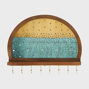 Wooden rack holds keys, featuring a perforated metal design with yellow and turquoise sections. The setting is against a plain white background.