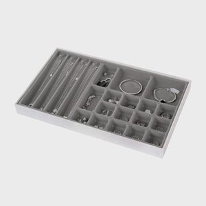 Jewelry organizer displays necklaces, rings, bracelets in various compartments; lies flat against a neutral background.