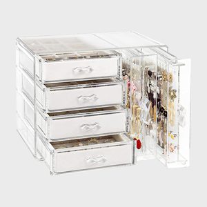 Transparent jewelry organizer, displaying necklaces and accessories, with four open drawers filled with various jewelry items, placed on a neutral background.