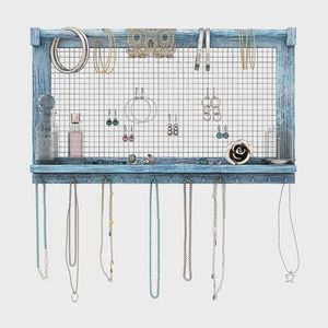 Jewelry organizer displays earrings, bracelets, and necklaces on a blue wooden frame with a grid back, holding bottles and accessories in a tidy arrangement.