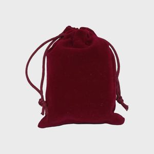 A red velvet drawstring pouch sits upright against a plain white background.