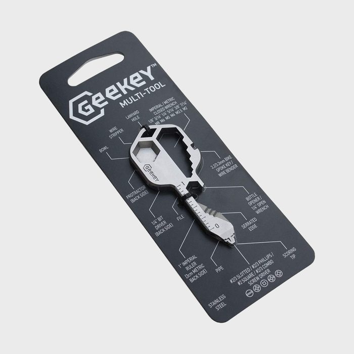 Multi-tool key sits on packaging, displaying various labeled functions like a wire stripper, bottle opener, and screwdriver, with text detailing each feature.