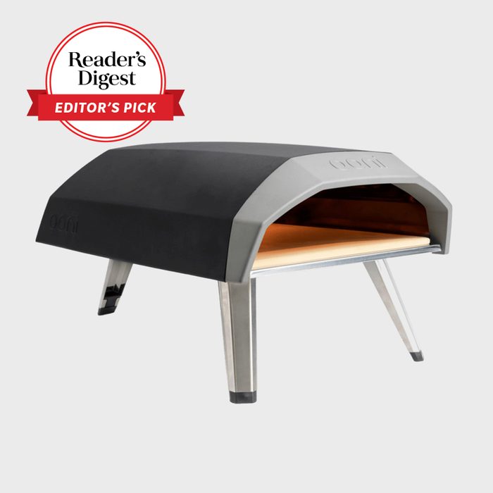 Pizza oven stands elevated, displaying its sleek black and silver design against a plain background, labeled 