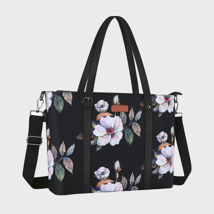 Floral-patterned black handbag with dual handles and detachable strap, set against a plain white background.