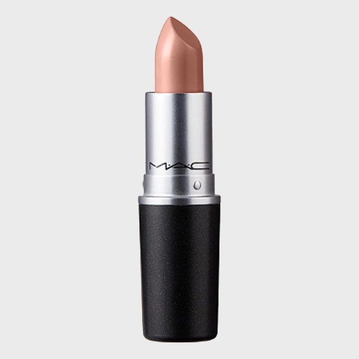 Lipstick stands upright, displaying a nude shade. Silver and black casing with 