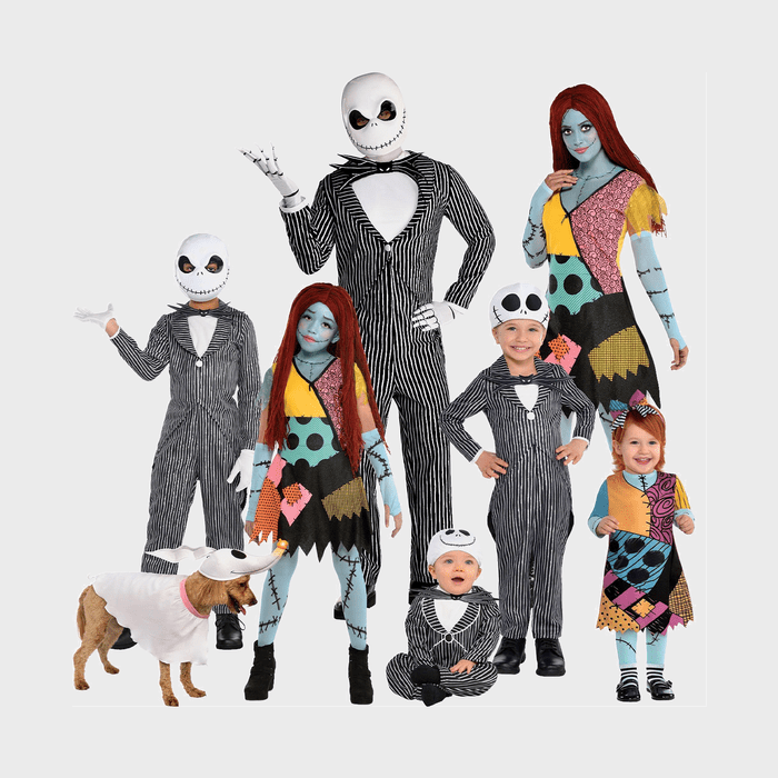 People wearing Halloween costumes pose together, with a ghostly dog nearby; costumes have stripes and patchwork designs.
