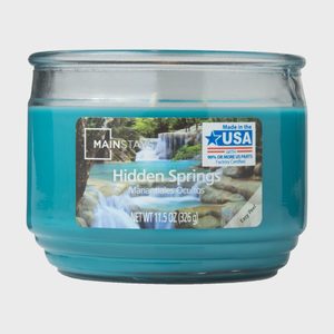 A blue candle sits in a glass jar labeled 