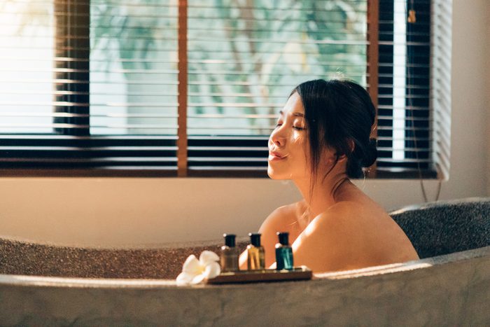young woman sitting in bathtub