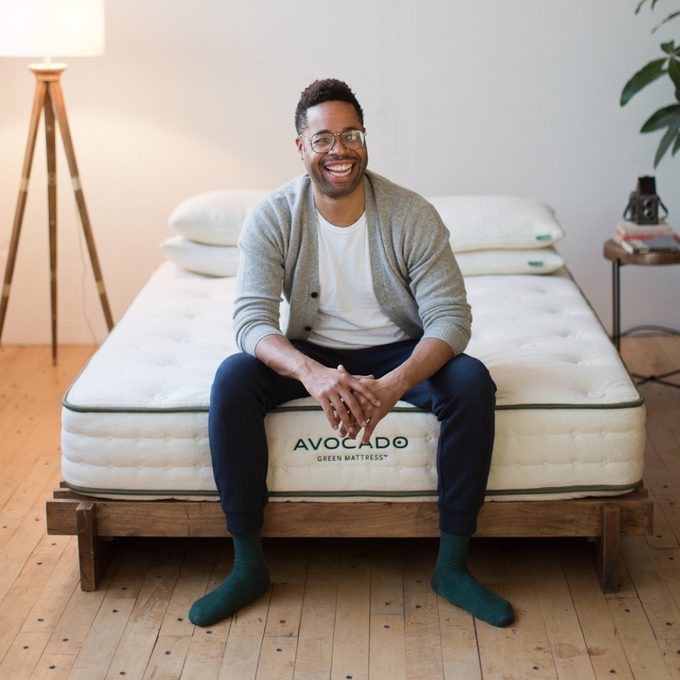 Person sits smiling on bed; text reads 