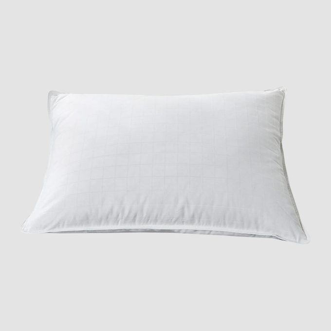 White pillow lies still against a plain gray background.