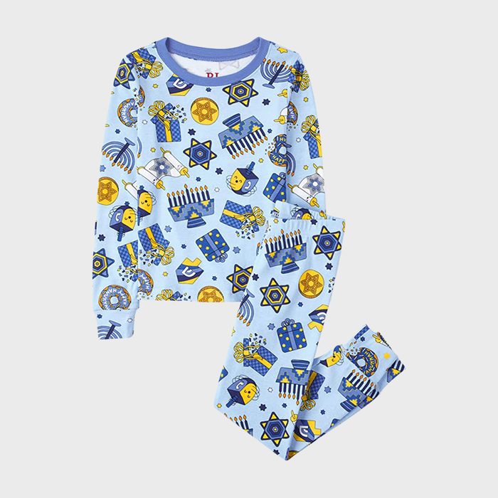 Blue pajamas featuring Hanukkah-themed patterns with menorahs, Stars of David, and dreidels, lying on a plain surface.