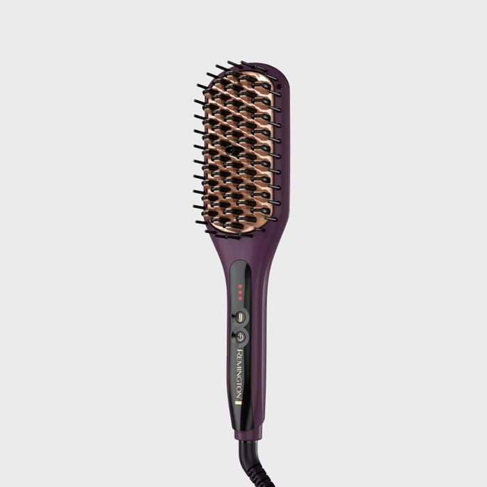 Heated hair straightening brush, featuring bristles and controls, lies on a plain white background. The brand 