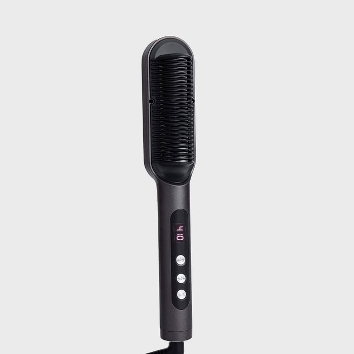 A black hair straightening brush with digital display, buttons visible, against a plain gray background.