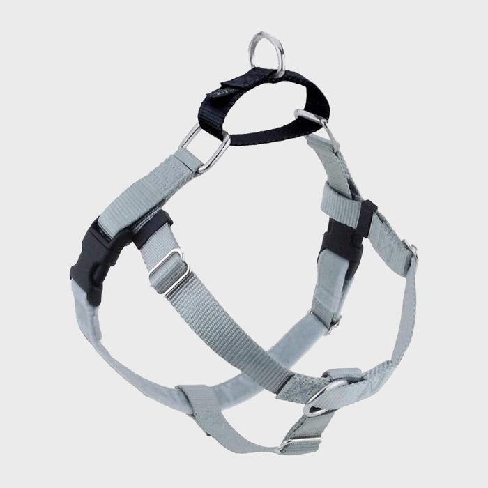 A gray and black adjustable harness with metal rings and buckles, suspended against a plain white background.