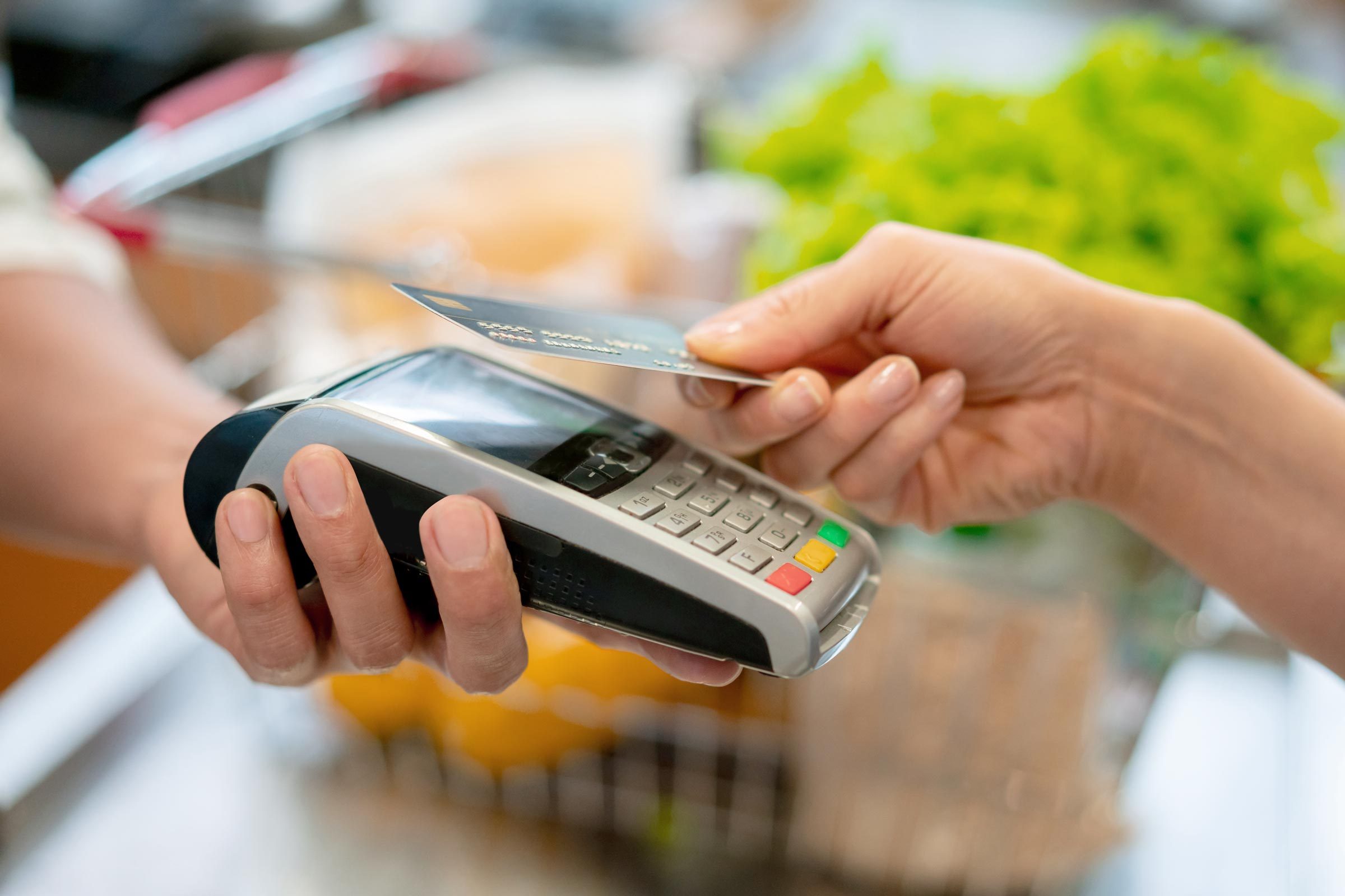 Close up of unrecognizable customer doing a contactless payment at the supermarket