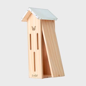 Wooden butterfly house stands upright, featuring vertical slots and a butterfly engraving, set against a plain, light gray background.
