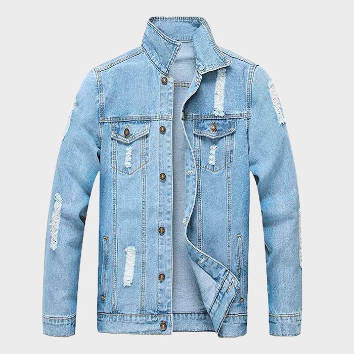 A light blue denim jacket with distressed patches is displayed against a plain white background, unbuttoned and showing front pockets with buttons.