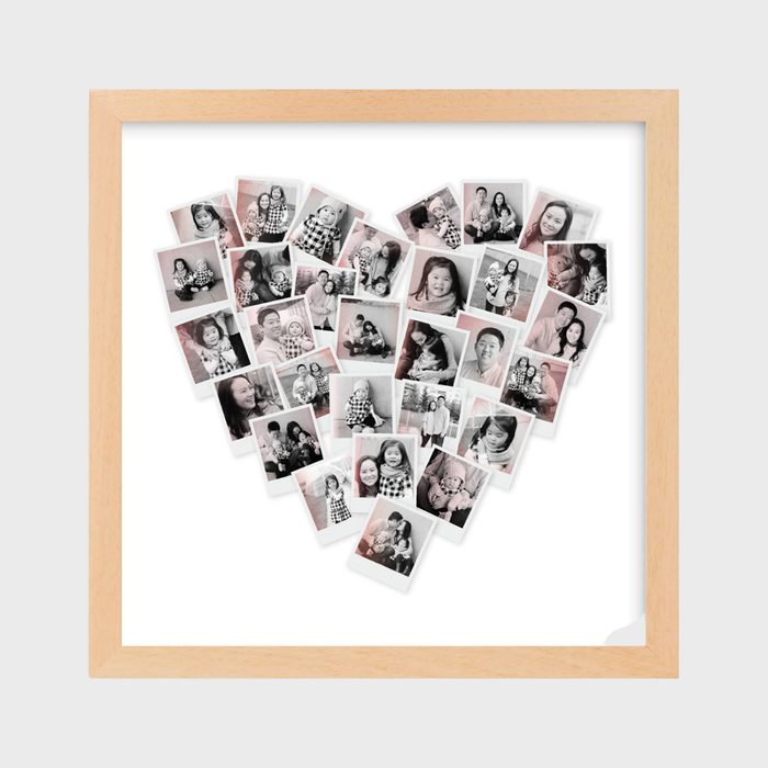 Photographs form a heart shape, displaying various people smiling and interacting, set in a wooden frame against a plain background.