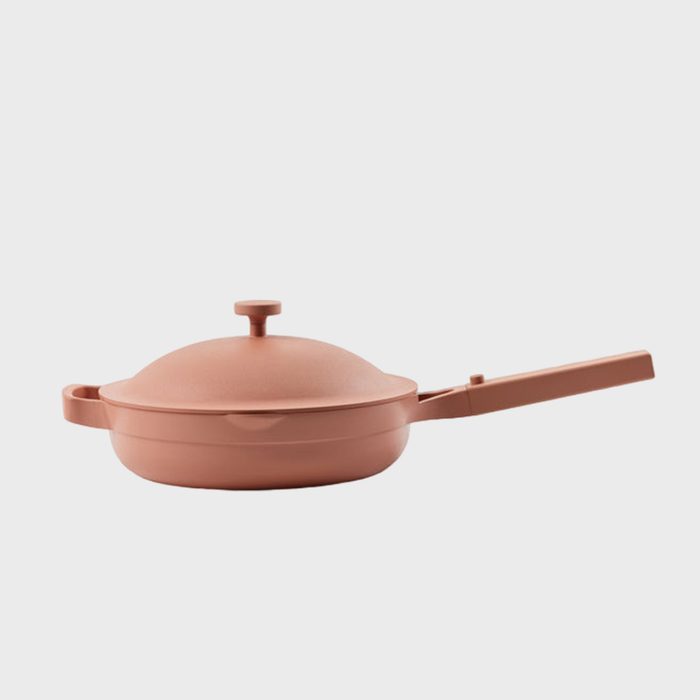 Terracotta frying pan with lid resting on a white background, featuring a long handle and circular knob on top.