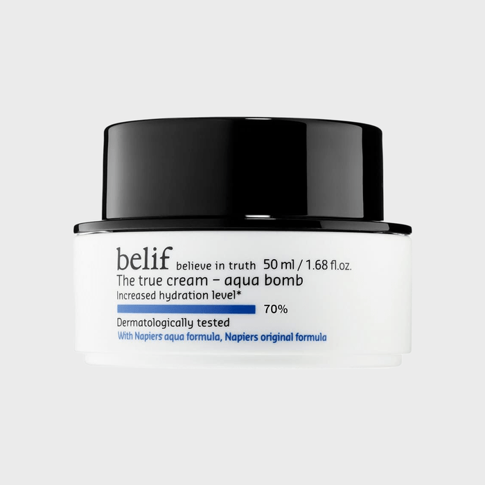 A white cosmetic jar with a black lid displays 
