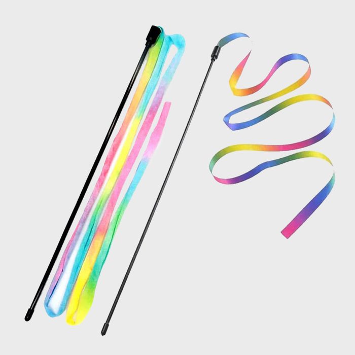 Rainbow ribbons attach to black sticks, lying flat against a plain background.