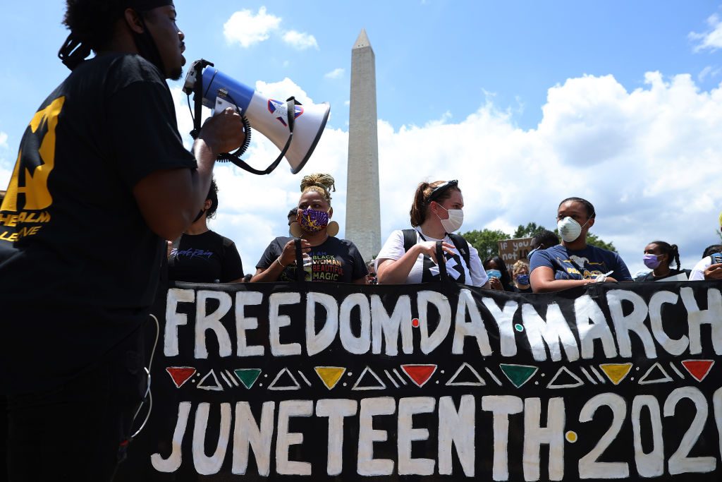 People march from the The National Museum of African American History and Culture to the Martin Luther King Jr. Memorial to mark the Juneteenth holiday June 19, 2020 in Washington, DC.