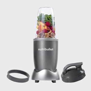 Blender with fruits and nuts inside, standing on a table, accompanied by two gray lids, featuring the logo 
