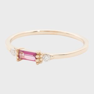 Gold ring featuring a rectangular pink gem flanked by two small round diamonds, set against a plain background.