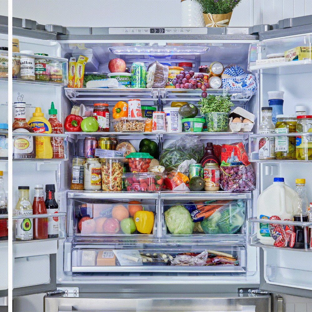 Refrigerator holds various food items and drinks, including fruits, vegetables, condiments, and dairy, organized in a well-stocked kitchen setting.