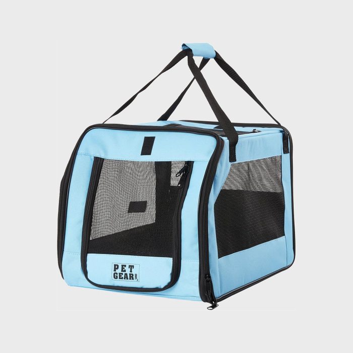 A blue pet carrier stands with mesh windows and a black handle, labeled 
