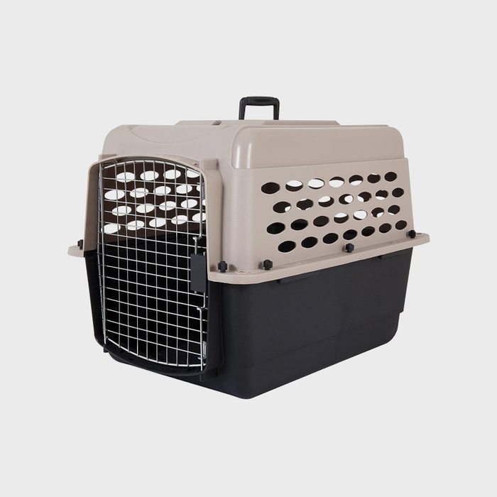Plastic pet carrier with metal door, sitting idle, against a plain white background.