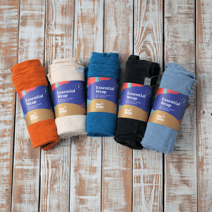 Five colorful fabric wraps lie on a wooden surface. Each is labeled 