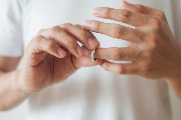 A young man is removing his wedding ring a concept of relationship difficulties