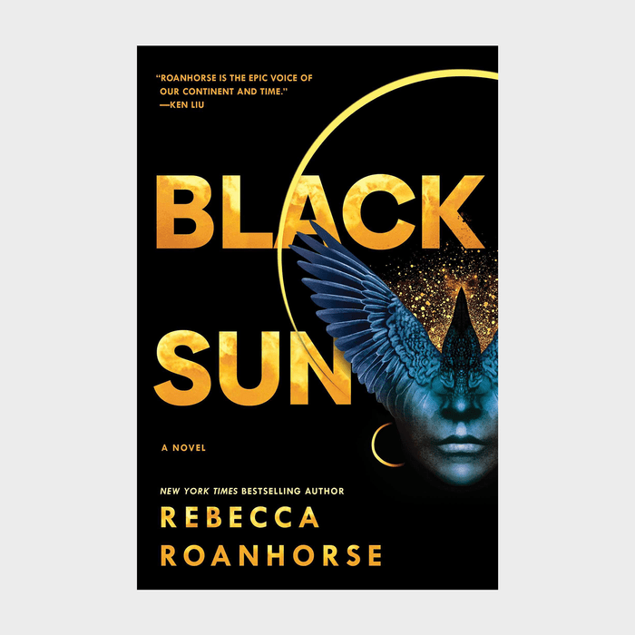 Book cover shows a blue bird overlaid on a face with shimmering gold text: â€œBlack Sunâ€ by Rebecca Roanhorse, highlighted by a vivid eclipse.