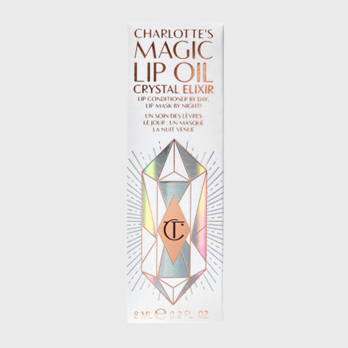 Box displays lip oil with holographic crystal design, copper text: 