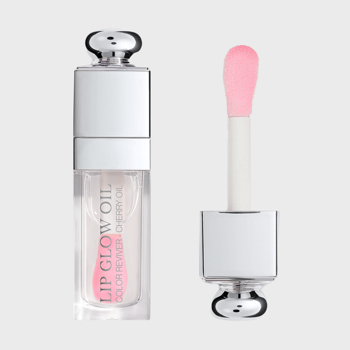 Lip gloss container and applicator, sitting separately; silver cap, pink-tinted applicator; labeled 