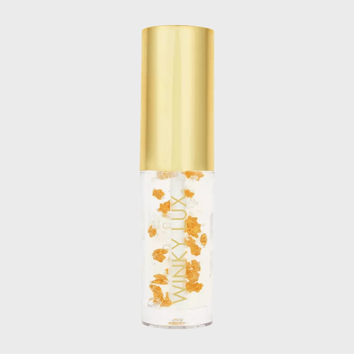 Clear lip gloss bottle with floating gold flakes, labeled 