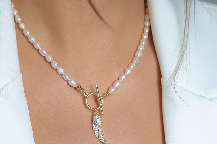 Closeup shot of a key pearl necklace worn by a Caucasian female.