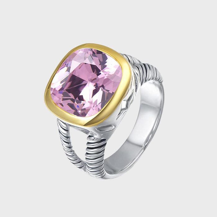 A silver ring with a large, faceted pink stone set in a gold bezel, against a plain white background.
