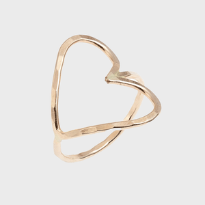Gold heart-shaped ring, featuring a hammered texture, positioned to reveal its open design, isolated on a plain light gray background.