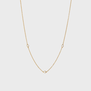 Gold necklace displaying three evenly spaced small diamonds on a delicate chain, set against a plain white background.