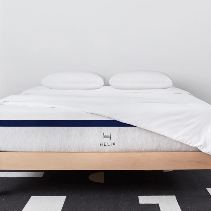 Bed with white sheets and pillows; mattress is labeled 
