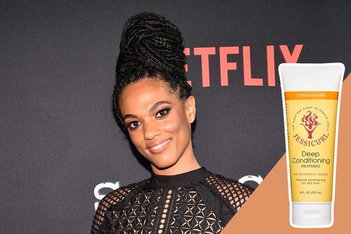A person poses in front of a Netflix backdrop, wearing a lacy black outfit. A Jessicurl Deep Conditioning Treatment bottle is shown beside them.