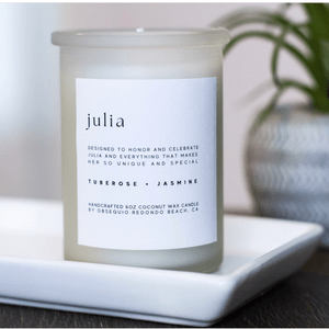 Candle sits on a white tray, featuring tuberose and jasmine, with text honoring 